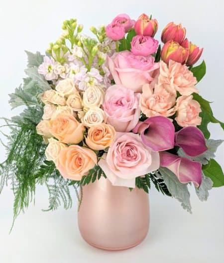 Perfect blush, cream, pink and coral create an elegant mix of fresh flowers. These trendy and beautiful flowers are the perfect gift! Garden roses, spray roses, hydrangea and elegant premium textures placed in a rose gold glass vase.