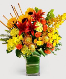 orange pin cushion protea with red and yellow assorted flowers in vase