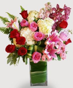 This beautiful design features our leaf-wrapped signature clear vase. Pink, red and white lilies, roses, and hydrangea are nestled amongst other floral textures and finished with elegant greens.