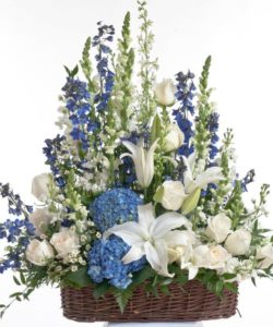 Floor basket design featuring an assortment of blue and white flowers including roses, delphinium, and hydrangea. Approximate size for the standard design is 20"W x 24"H
